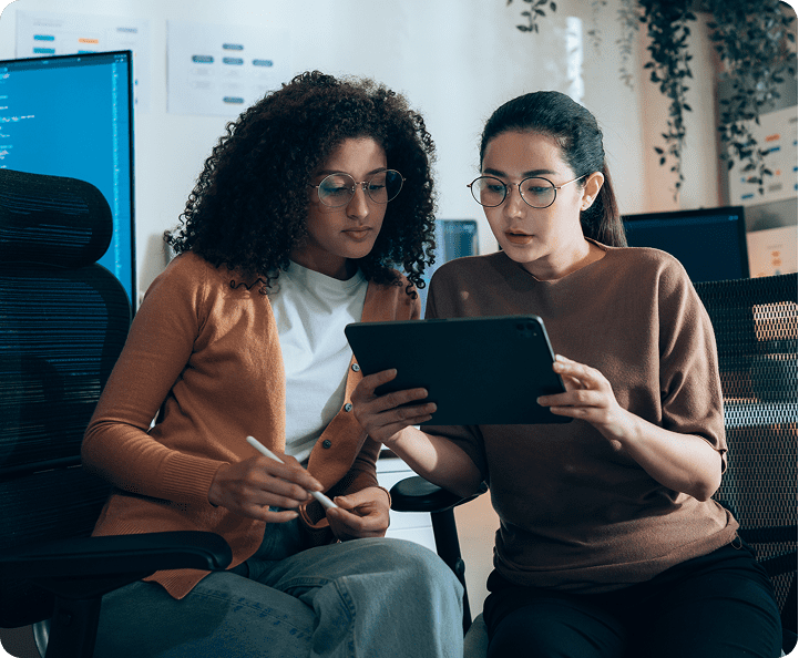Women collaborating in office with tablet